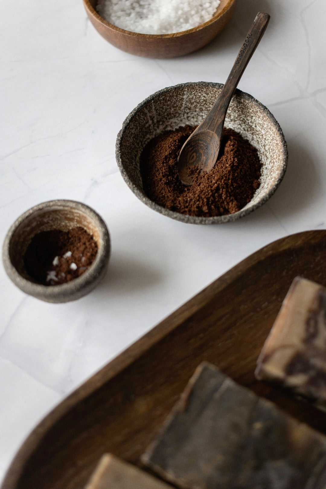 mac + mitchell anti cellulite coffee scrub in hand showing coffee grounds and oil blend