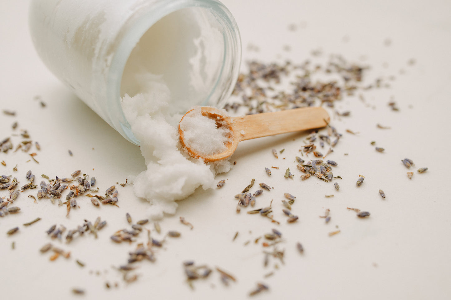 mac + mitchell botanical body polish sugar scrub spilling from glass jar with wooden scoop