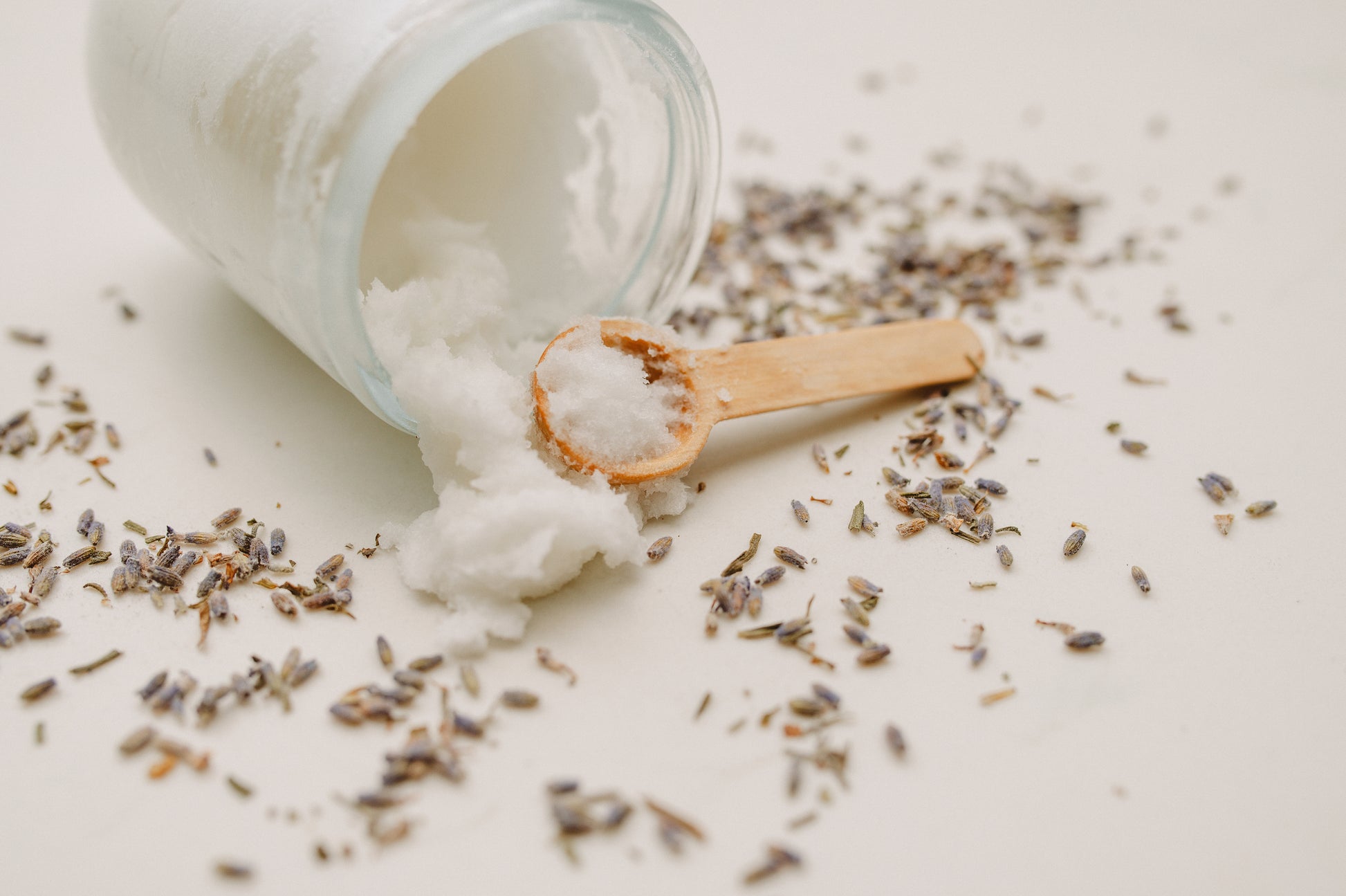 mac + mitchell botanical body polish sugar scrub spilling from glass jar with wooden scoop