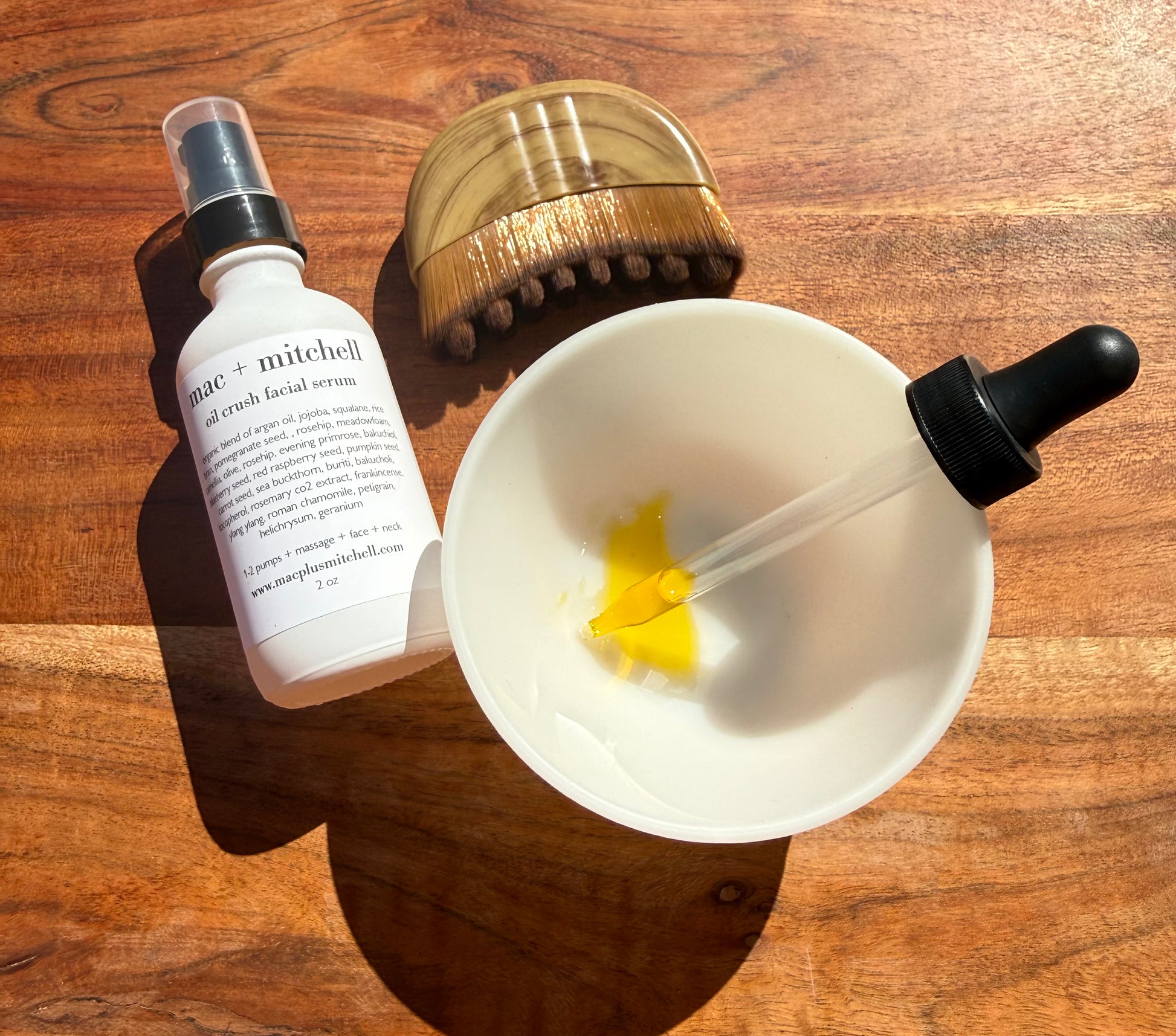 ac + mitchell oil crush facial serum bottle with glass dropper on wood surface