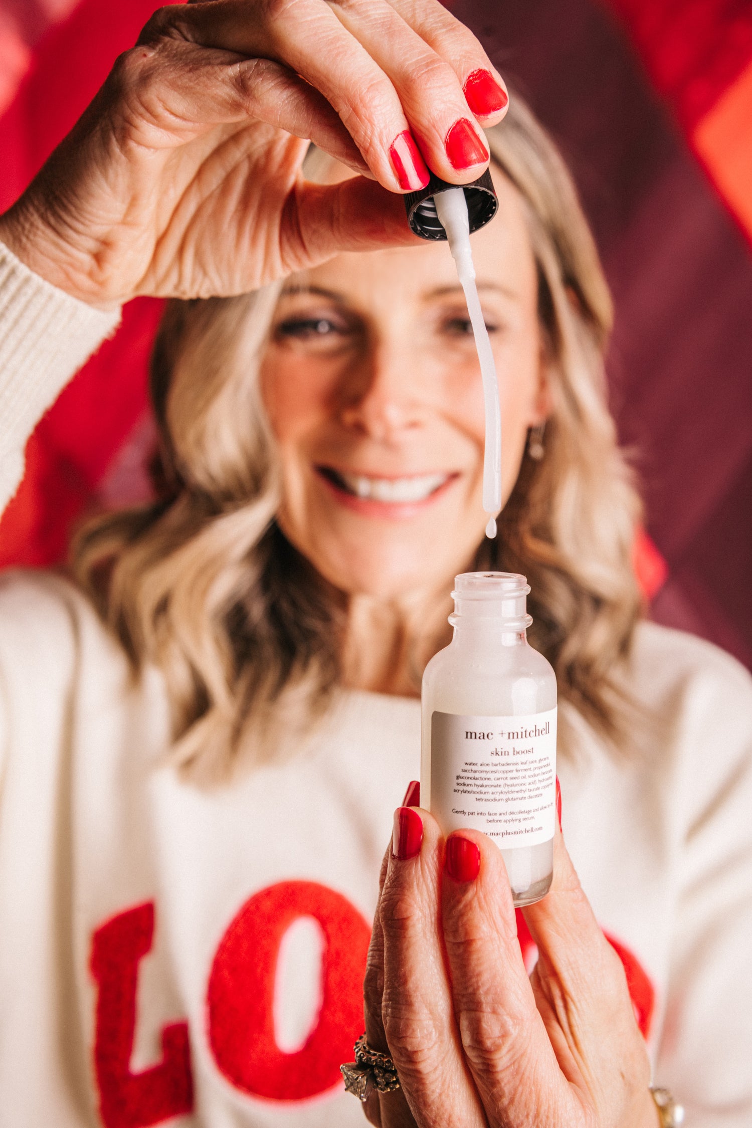 mac + mitchell founder kelly goodwin applying skin boost serum with dropper