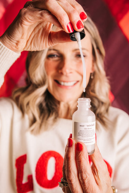 mac + mitchell founder kelly goodwin applying skin boost serum with dropper