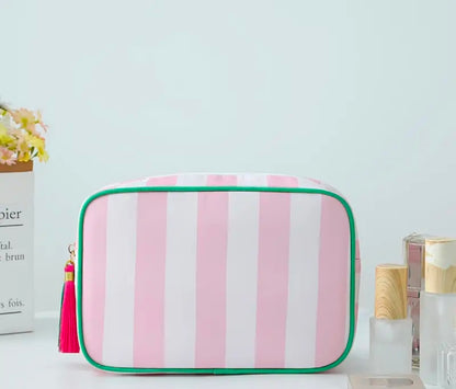 mac + mitchell striped cosmetic bag filled with skincare products on pink background