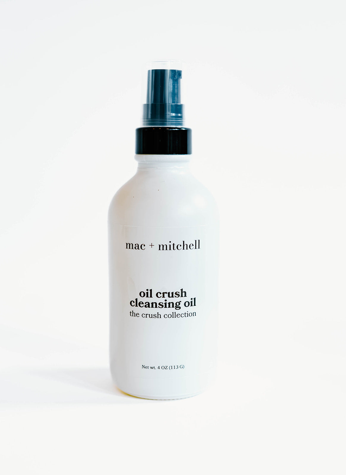 white glass bottle of oil crush cleansing oil with a black pump top.