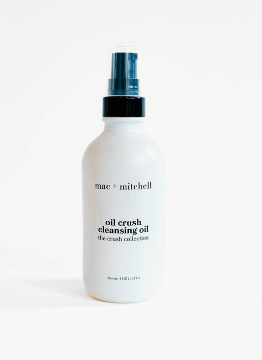 white glass bottle of oil crush cleansing oil with a black pump top.